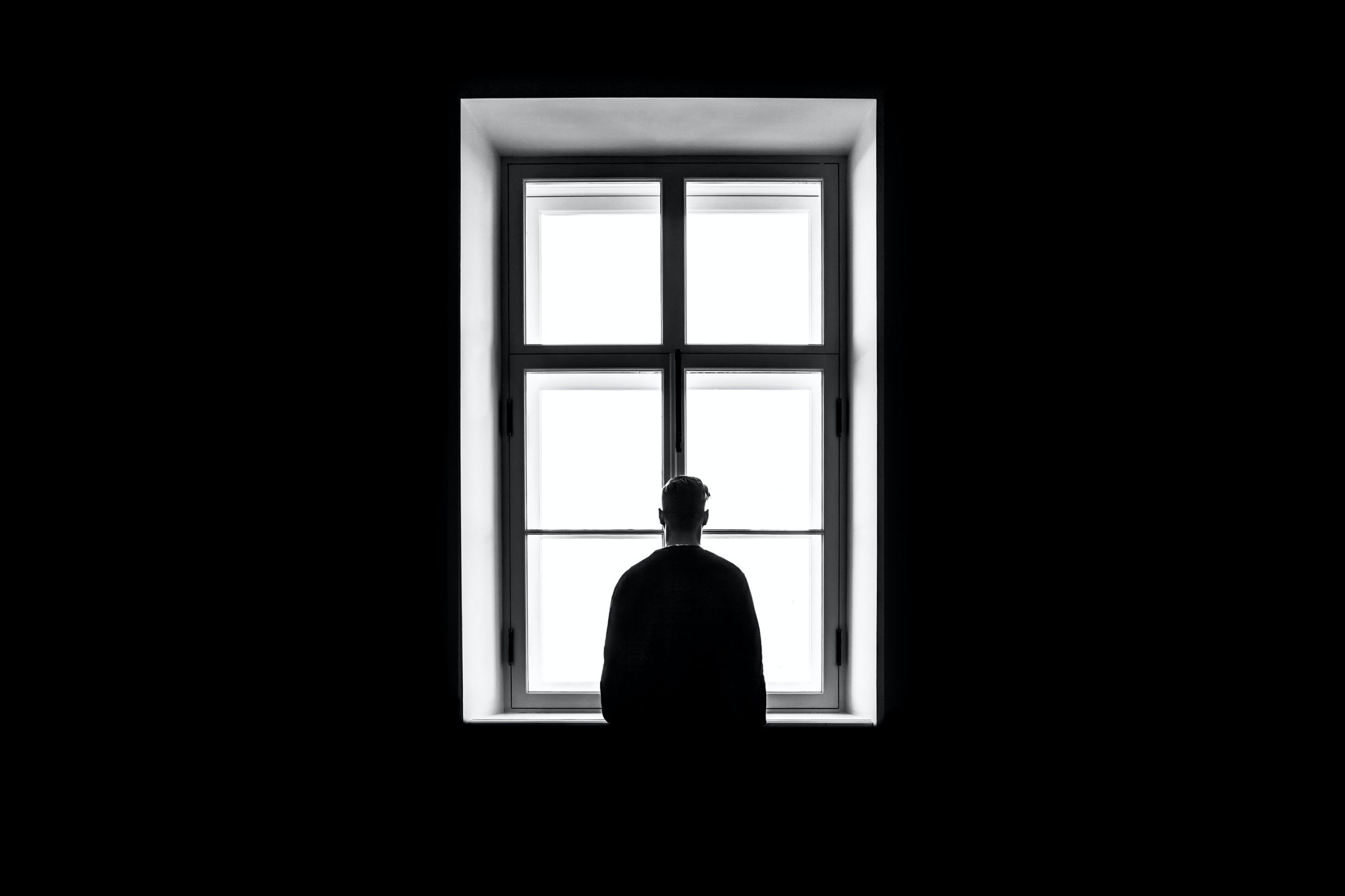 Isolated worker stares out of window alone